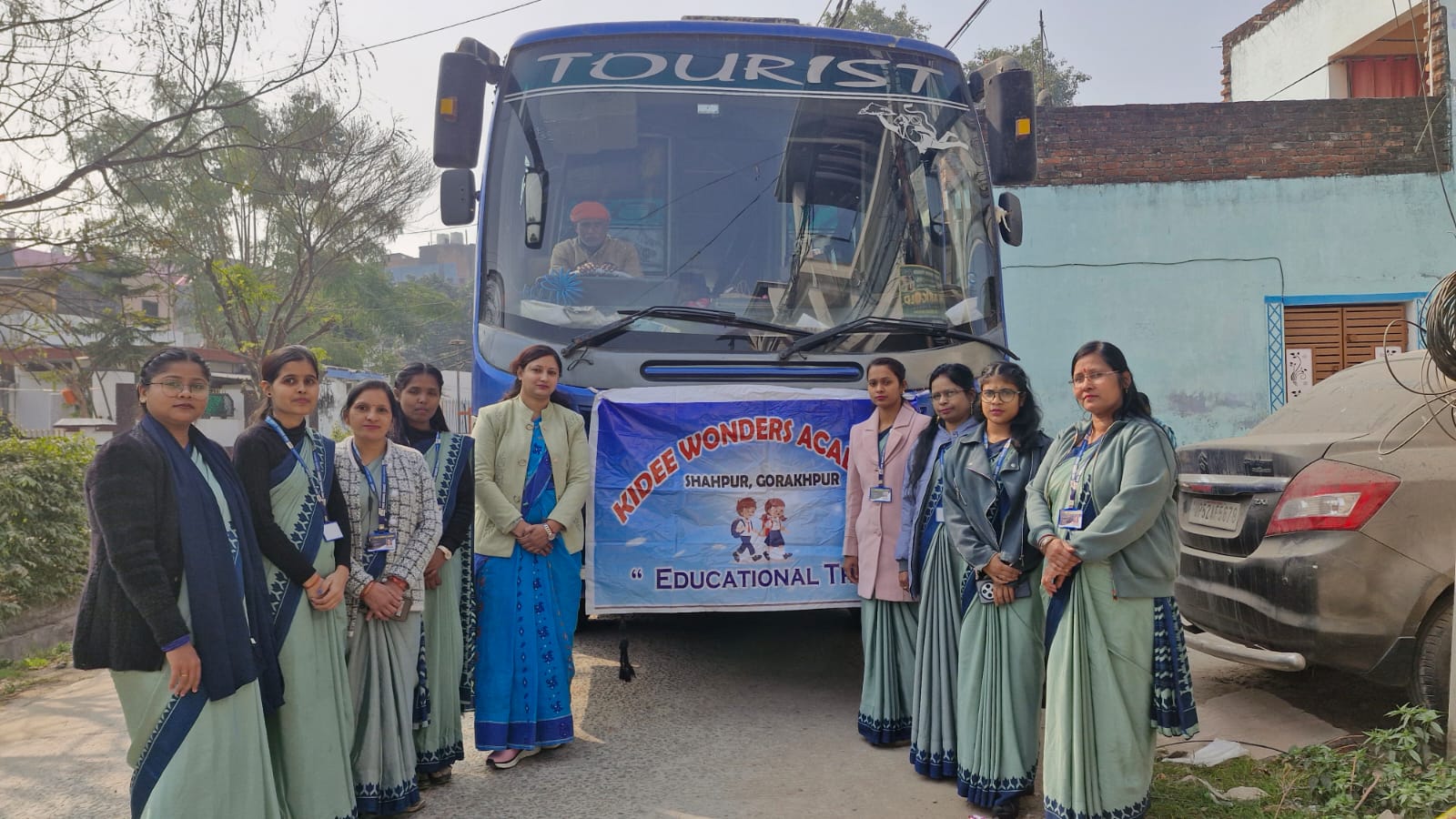 Teachers gathered beside the bus before the school picnic