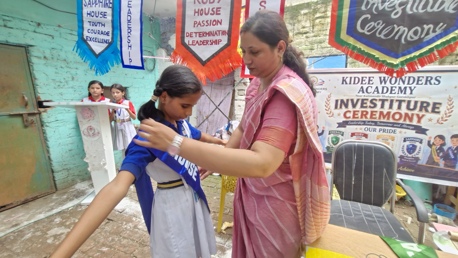 A student receiving a blue house captain sash